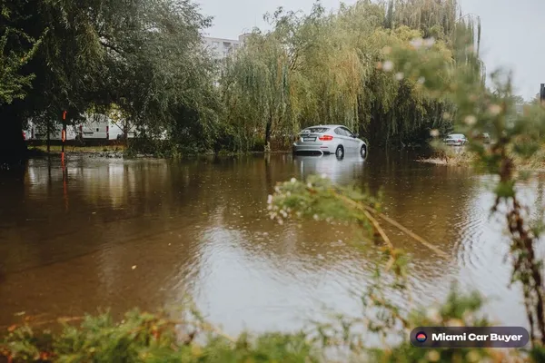 Flood-damaged car sitting in water, representing the kinds of vehicles sold through Miami Car Buyer